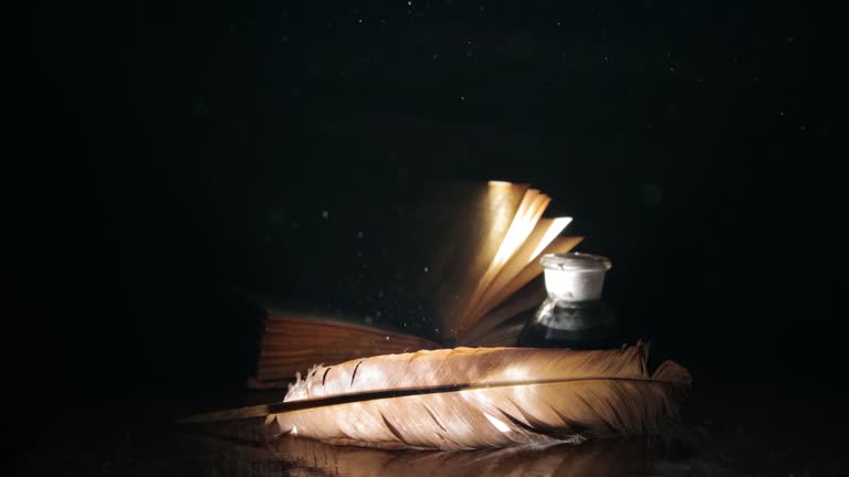 Book, pen and inkwell in a ray of light