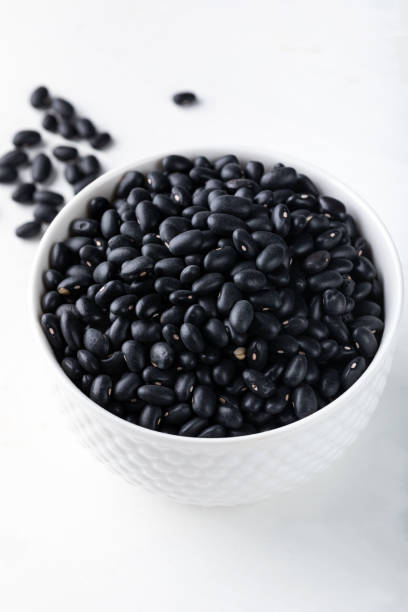 istock Black beans in a white porcelain bowl on a white 1937757748