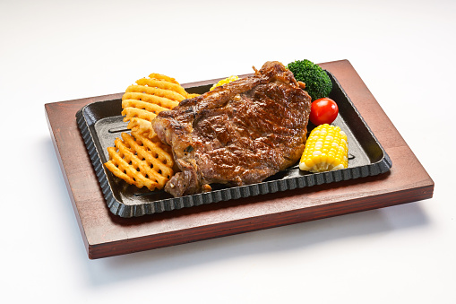 Air Fryer Sirloin Steak with corn, tomato and broccoli served in dish isolated on wooden table side view of hong kong fast food