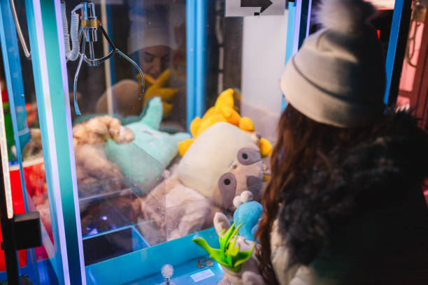 istock Woman playing an arcade claw machine game 1937780223