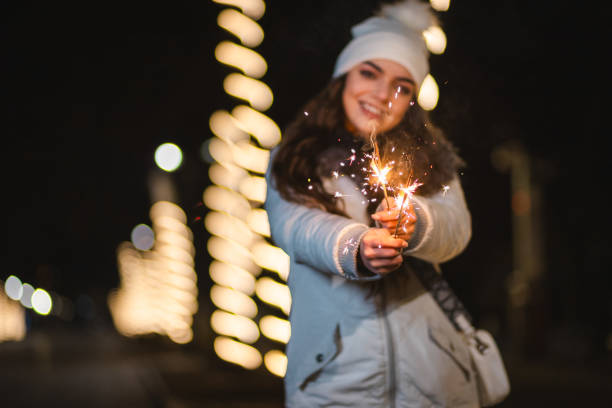 istock Beautiful woman posing with sparklers outdoors while celebrating New Year's 1937785430