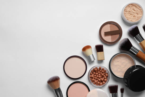 istock Different face powders and makeup brushes on light background, flat lay. Space for text 1937799748