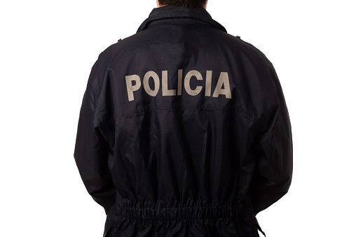Rear view of a policeman in blue uniform on white background