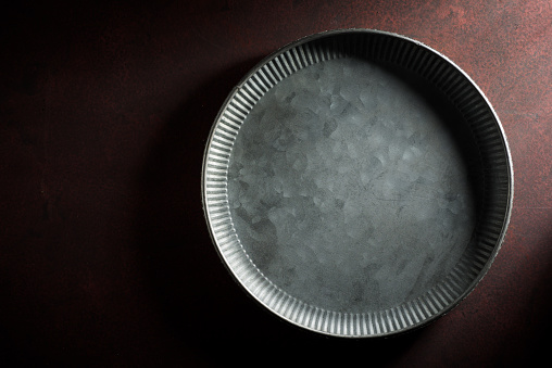 Close up of a empty metal plate on a kitchen table