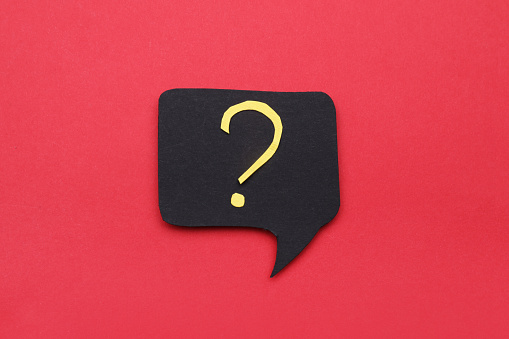 Paper speech bubble with question mark on red background, top view