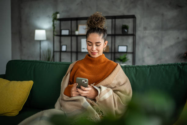 istock A young beautiful woman using a smart phone at home 1937830860
