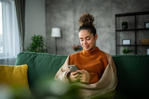 istock A young beautiful woman using a smart phone at home 1937831377