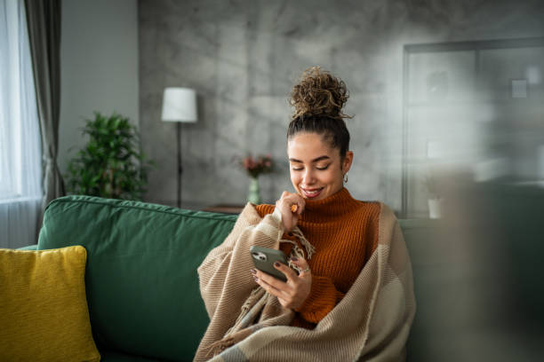 istock A young beautiful woman using a smart phone at home 1937831383