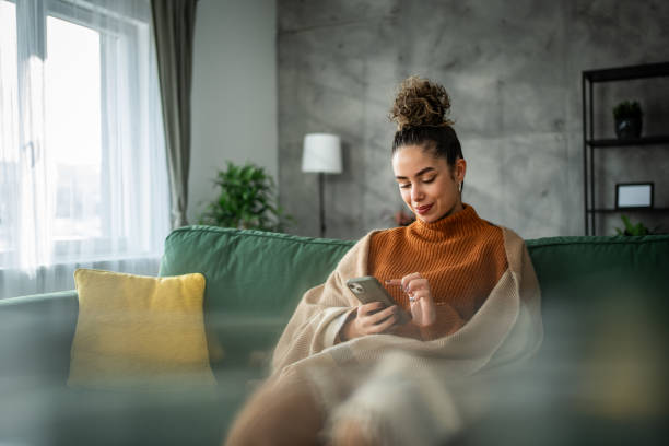 istock A young beautiful woman using a smart phone at home 1937831917