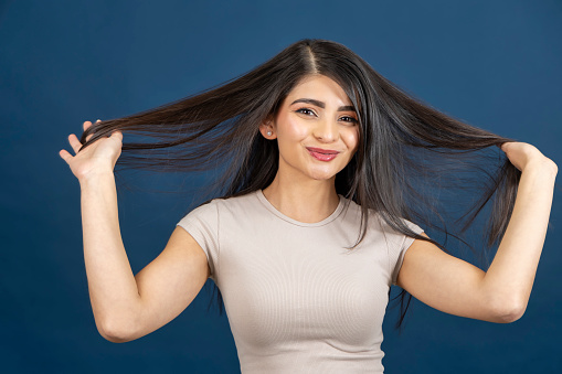 Young woman proudly showing off the length of her hair