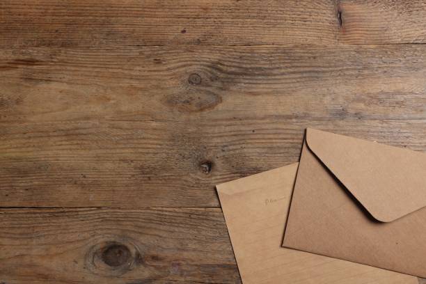 istock Envelope and sheet of parchment paper on wooden table, flat lay. Space for text 1937849721