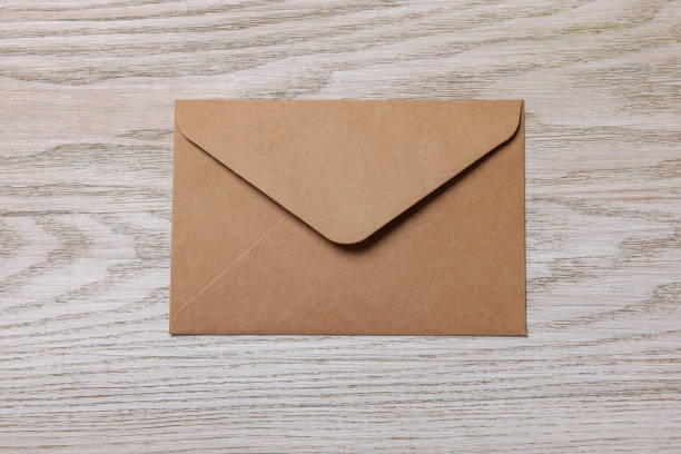 istock Paper envelope on white wooden table, top view 1937850797