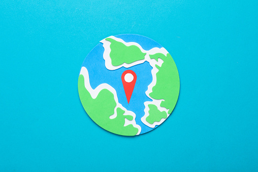 Gps geolocation point (location pin) and globe on blue background