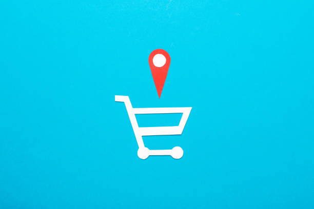 Paper cut shopping trolley and Geolocation Maps Marker point icon on blue background