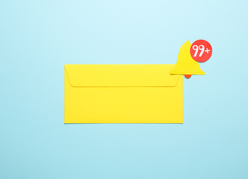 Yellow Envelope and Paper cut notification bell icon on blue background
