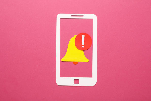 Paper cut smartphone and notification bell icon on pink background