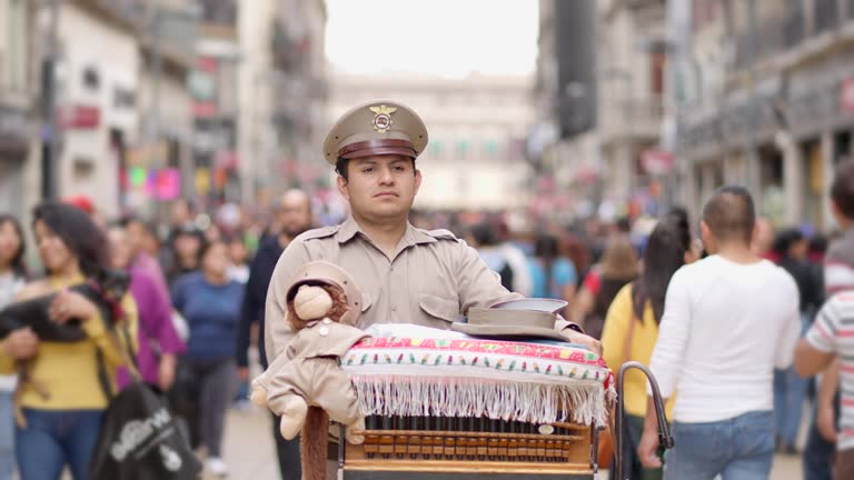 Mexican Cityscape: Traditional Organ Grinder playing music in german harmonipan in Madero Street, Mexico City - CDMX