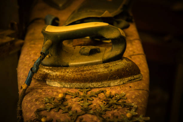 A modern electric iron resting on an ironing board with a shirt, captured in a minimalistic home setting. Soft lighting and a blurred background create a calm and organized atmosphere.