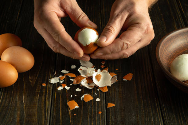 istock Chef hands peel boiled eggs for preparing a national dish on the kitchen table. Healthy egg diet concept 1937934633