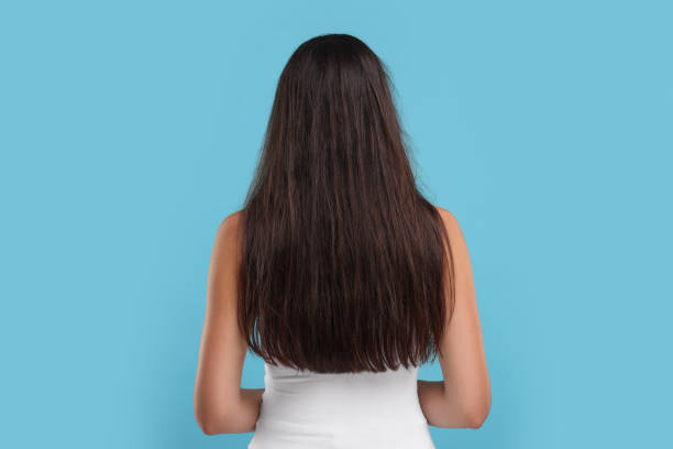 istock Woman with damaged messy hair on light blue background, back view 1937952830