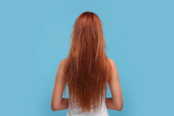 istock Woman with damaged messy hair on light blue background, back view 1937953879