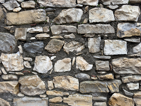 Panorama - Old gray wall of rough, many small, rectangular hewn natural stones