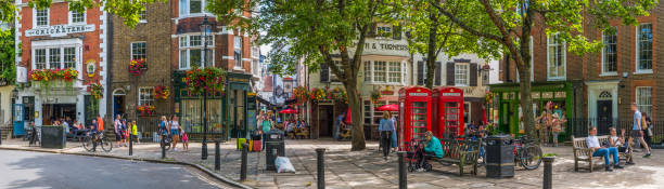 People walking along the leafy pavements of Richmond upon Thames outside London, UK.