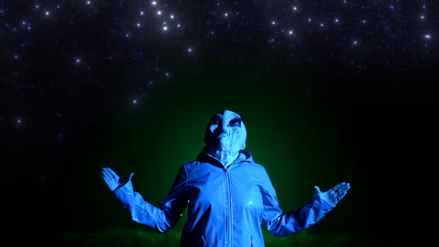 Alien portrait opens arms stars on night sky. UFO, extraterrestrial, halloween