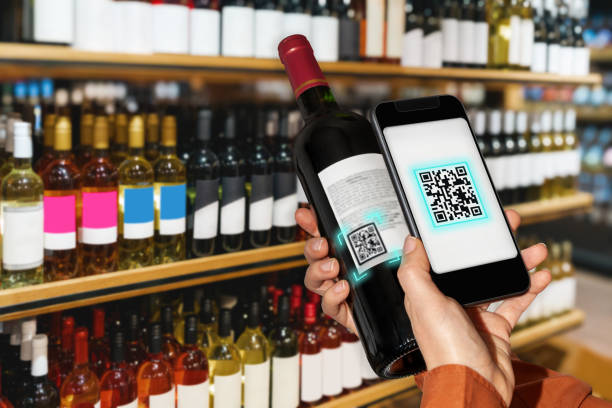 сканирование электронной этикетки винной бутылки с помощью смартфона в винном магазине. - coding qr code wine bottle label стоковые фото и изображения