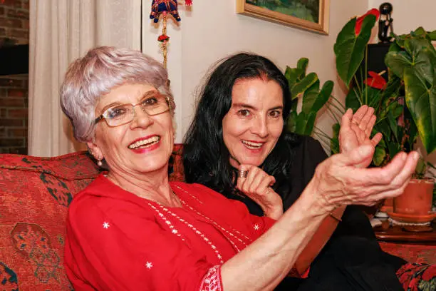 Two Colombian ladies, an older lady with her niece, appear to be enjoying a joke at the expense of the photographer. It is party time for the senior lady!