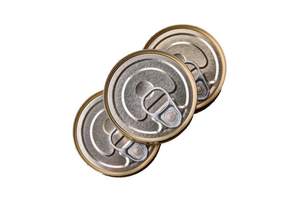 Round metal can with canned fish or meat with a key on a concrete texture background