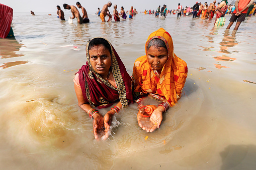 Ganga Sagar, West Bengal, India, 01_14_2024: Women devotees taking holy bath at Gangasagar. After the bath they perform pujas and other rituals in remembrance of their departed family members/close relatives and they also seek blessings for their departed souls.Gangasagar pilgrimage and fair, held annually, is the second largest congregation of mankind after the holy Kumbha Mela. Almost a million of Hindu devotees from all over India gather at Gangasagar for a holy dip and perform rituals and prayer (puja) with a belief that it will cleanse and purify their souls.\nGangasagar Festival is in Hinduism, held every year at Gangasagar, West Bengal, India. The confluence of the Ganges and the Bay of Bengal is called the Gangasagar, the fair is held every year on Makar Sankranti at Kapilmuni's ashram located on the Gangasagar. The mela is celebrated on 14 or 15 January every year.