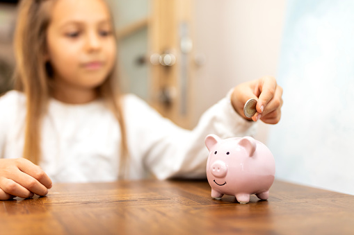 Shot of a cute young girl with a piggybank