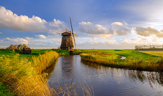Dutch Windmill along a Canal near Schermerhorn, Netherlands, during dusk