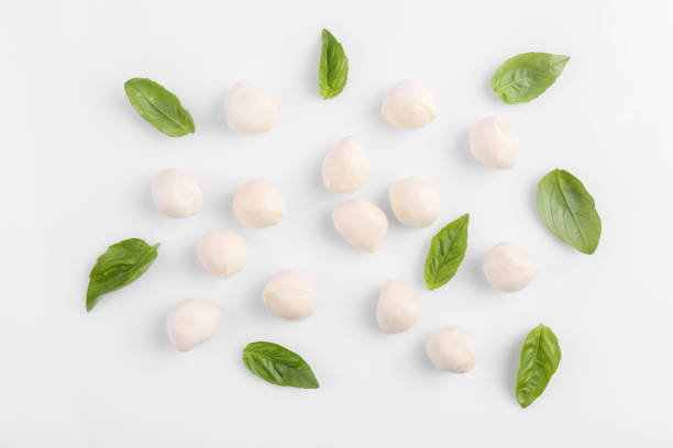istock Tasty mozzarella balls and basil leaves on white background, flat lay 1938199157