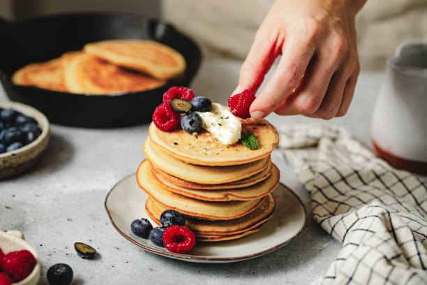 istock Woman hand preparing pancakes at home 1938207060