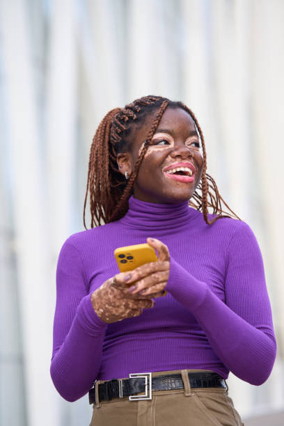 istock Joyful Woman Messaging on Yellow Smartphone 1938258346