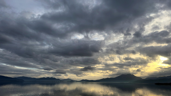 Stormy clouds and its reflection on Köyceğiz Lake, in the sunset, mountains on the other side of the lake, sunbeam of the sunset, dramatic lake view,