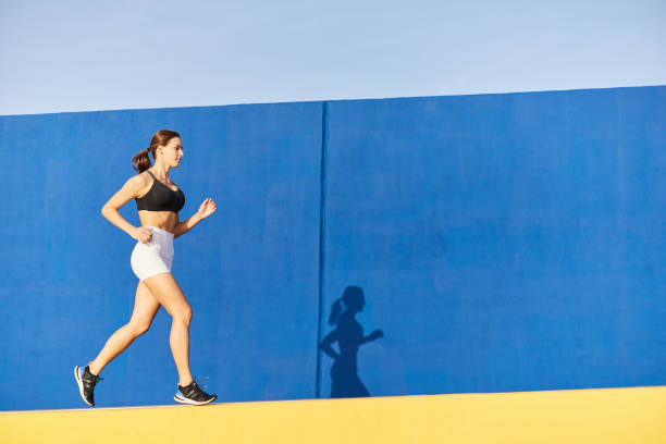 istock Fit runner jogging outside near blue wall 1938313768