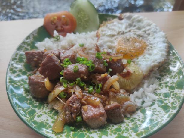 istock breakfast menu containing beef steak, egg, rice with additional slices of cucumber and tomato 1938381723