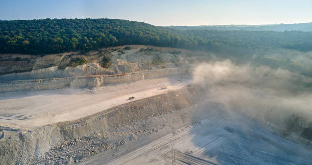 istock Aerial view of open pit mining site of limestone materials extraction for construction industry with excavators and dump trucks. 1938383382
