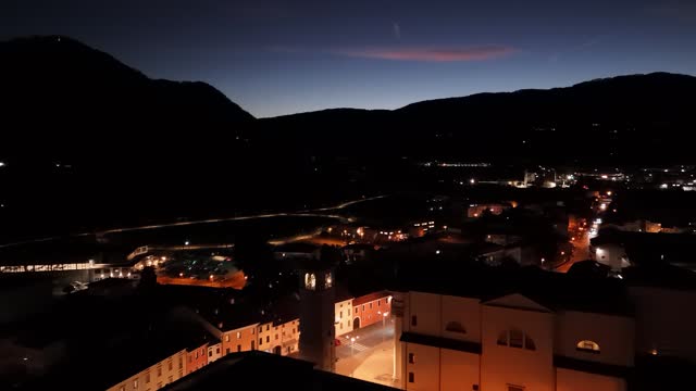 Malo Italian town illuminated at twilight. Aerial dolly in