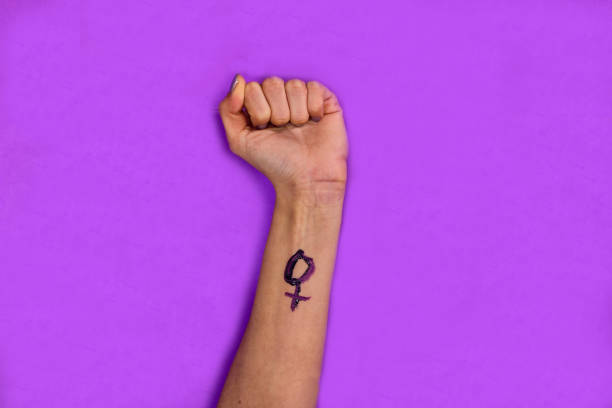 istock A woman's fist raised on a violet background 1938388230