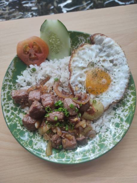 istock breakfast menu containing beef steak, egg, rice with additional slices of cucumber and tomato 1938396017