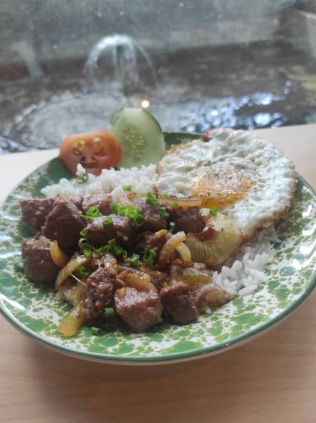 istock breakfast menu containing beef steak, egg, rice with additional slices of cucumber and tomato 1938396545