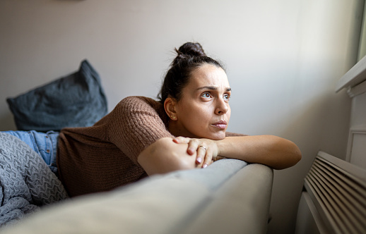 Portrait of depressed woman sitting alone on the sofa