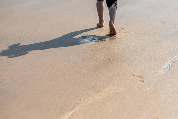 A child's feet walking on the beach