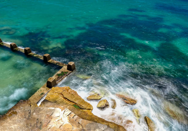 istock Powerful white swirling waves (blurred motion) crashing into rocky coastline 1938453957