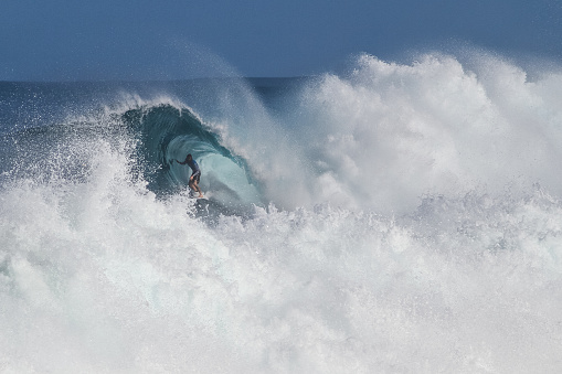 December 9th 2023, North Shore, Oahu, Hawaii. A side view of mostly crashing waves and white water with a view inside a peeling wave with a surfer riding.