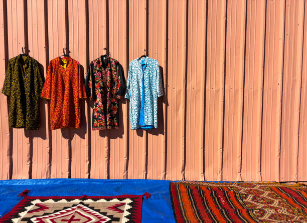 Colorful Uzbek Kaftans Hanging on Peach-Colored Wall